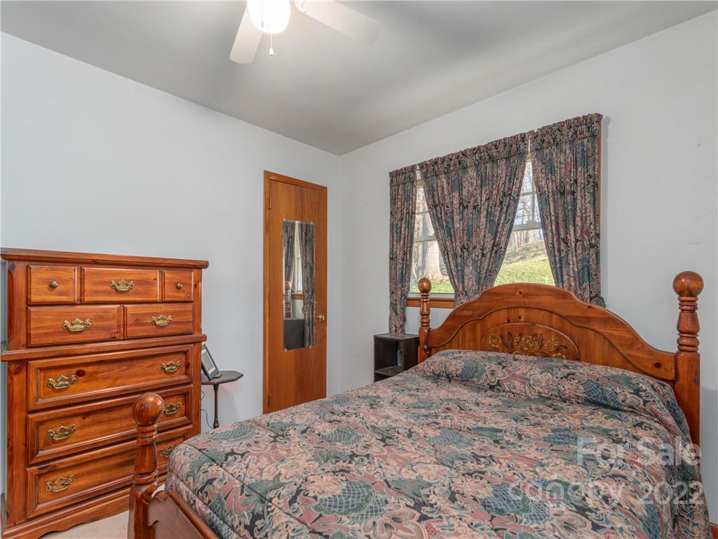 1179 Max Thompson Road Canton, NC 28716 - Photo 18 of 41 a bedroom with a bed and a dresser with wooden floor