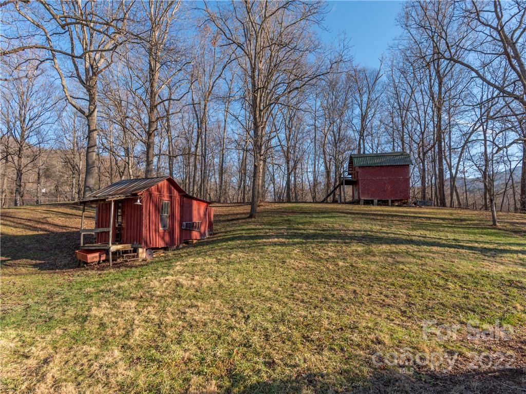 1179 Max Thompson Road Canton, NC 28716 - Photo 9 of 41 a view of a house with large trees and a yard