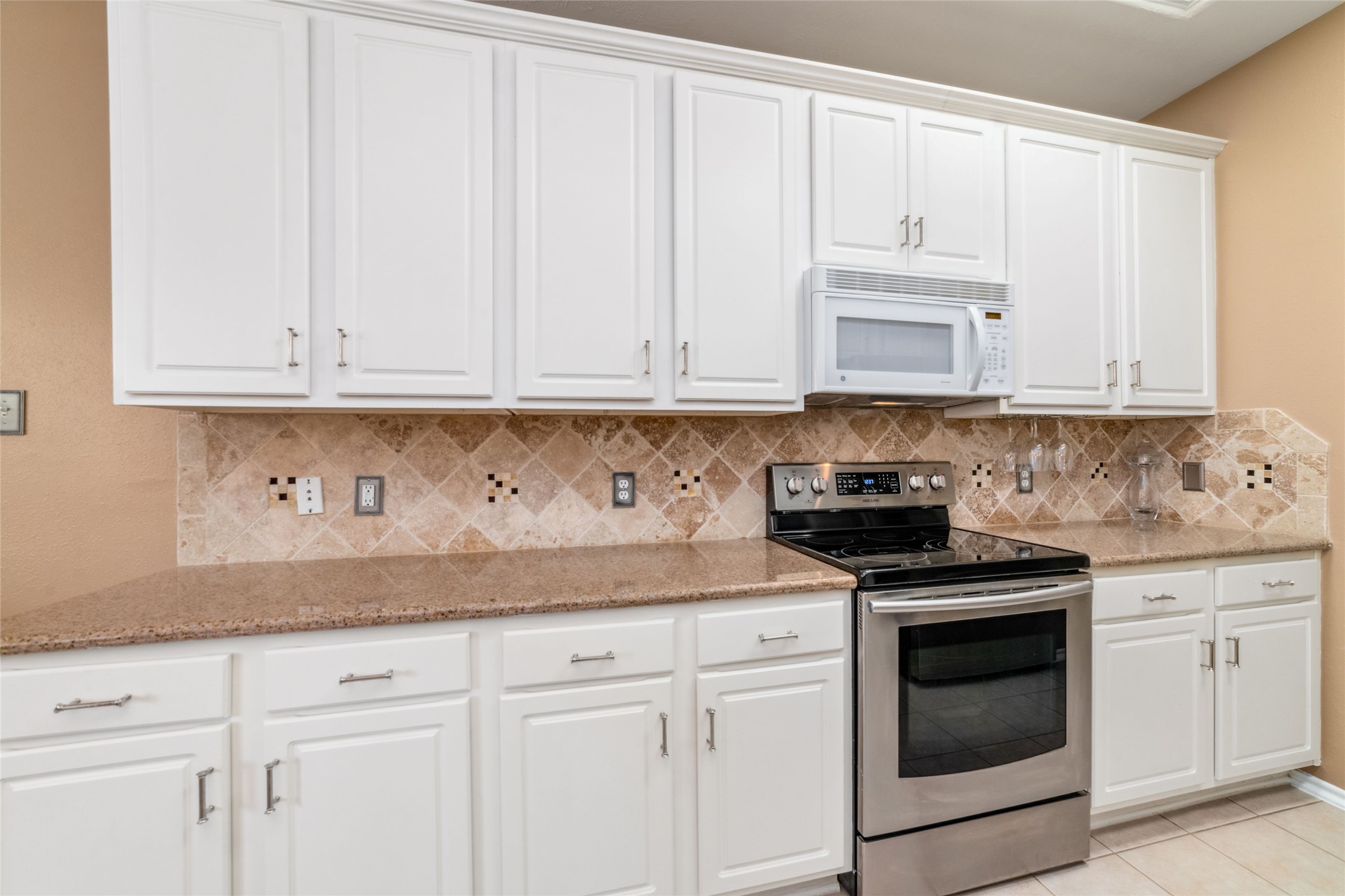 203 West Stedhill Loop Conroe, TX 77384 - Photo 12 of 45 a kitchen with granite countertop white cabinets and stainless steel appliances