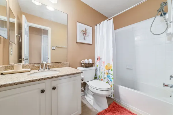 a bathroom with a granite countertop sink mirror vanity and toilet