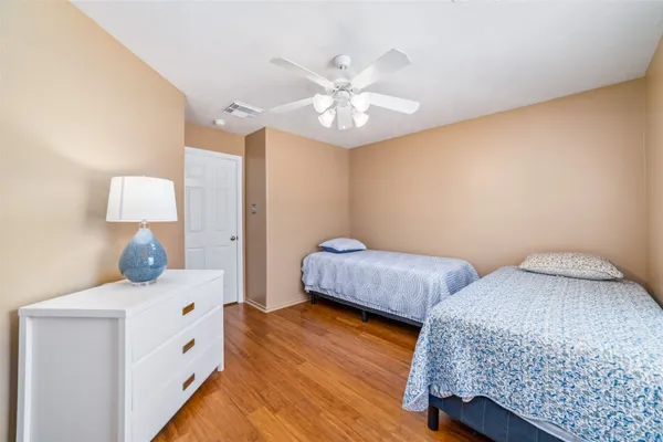 a bedroom with 2 bed and a chandelier