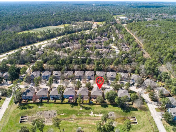 an aerial view of residential houses with outdoor space and trees