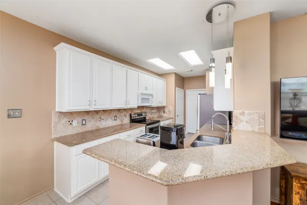 a kitchen with kitchen island a sink a stove and a refrigerator with wooden floor