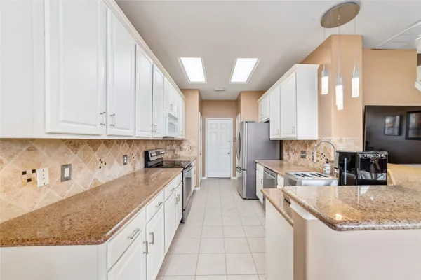 a kitchen with granite countertop a sink a stove and cabinets