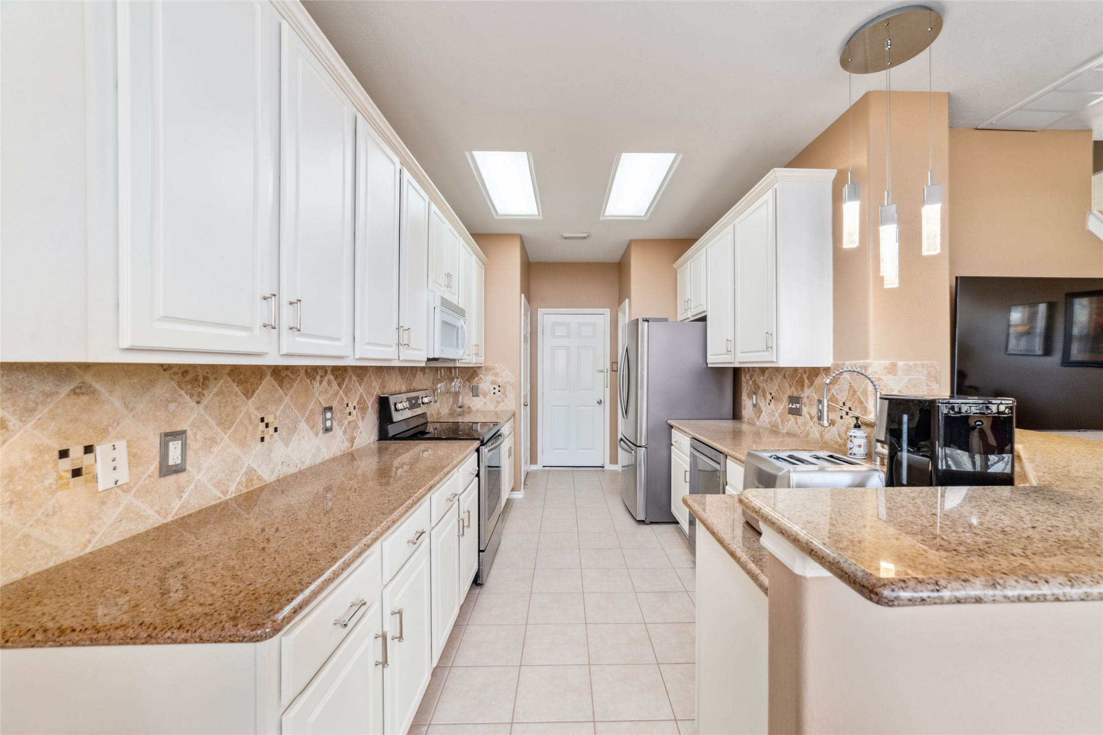 203 West Stedhill Loop Conroe, TX 77384 - Photo 10 of 45 a kitchen with granite countertop a sink a stove and cabinets