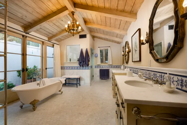 a spacious bathroom with a table chairs and a mirror
