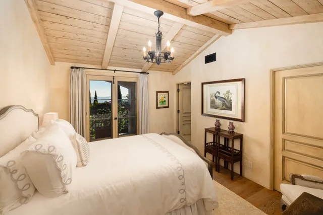 a bedroom with a large bed and a chandelier