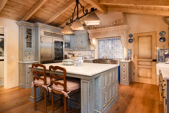 a kitchen with a table chairs refrigerator and cabinets