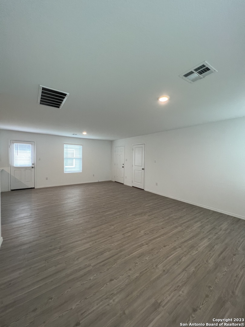 13819 Llama Place San Antonio, TX 78252 - Photo 11 of 37 an empty room with wooden floor and windows