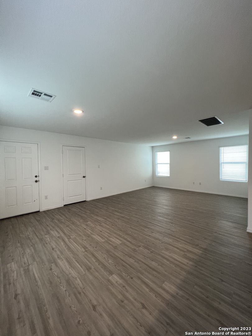 13819 Llama Place San Antonio, TX 78252 - Photo 12 of 37 an empty room with wooden floor and windows