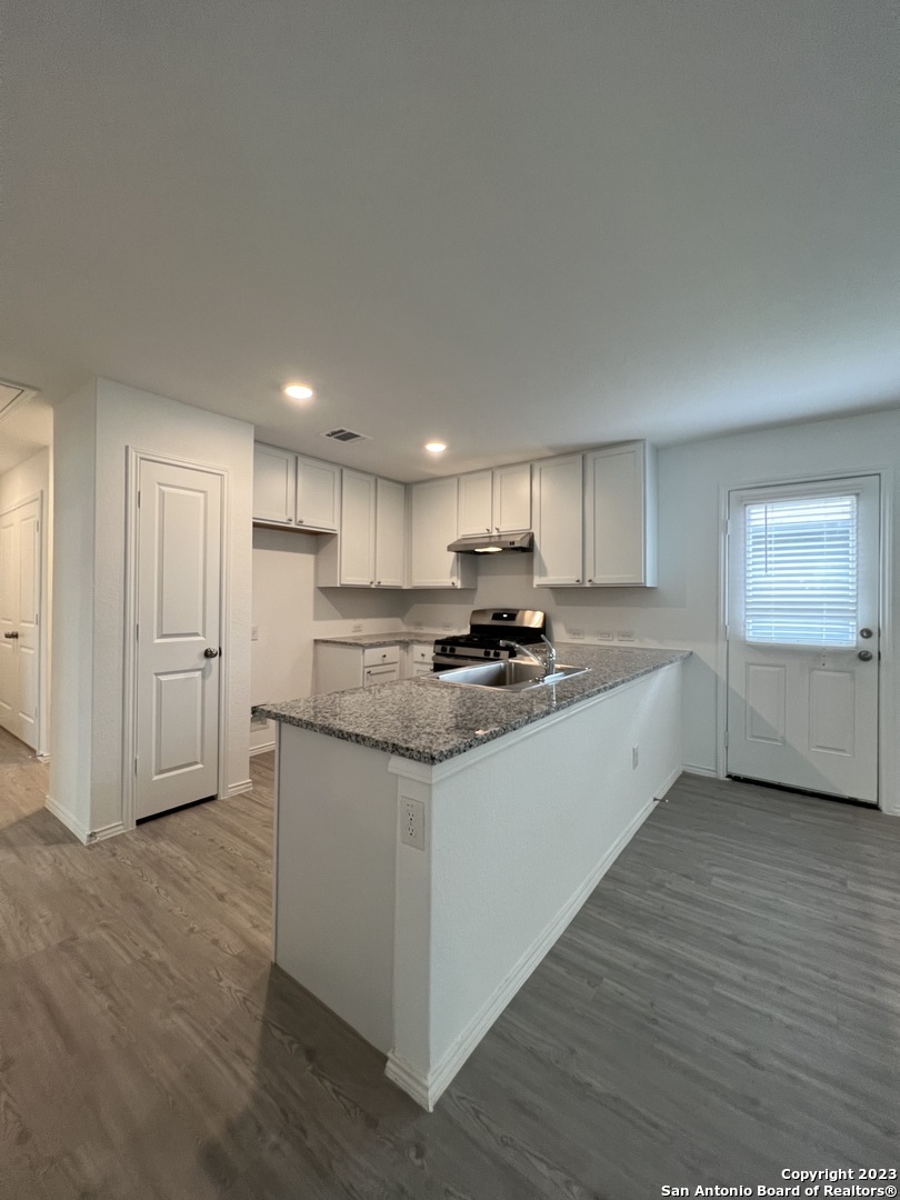 13819 Llama Place San Antonio, TX 78252 - Photo 13 of 37 a large kitchen with stainless steel appliances granite countertop a stove a sink and a refrigerator