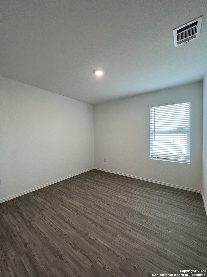 13819 Llama Place San Antonio, TX 78252 - Photo 18 of 37 an empty room with wooden floor and windows