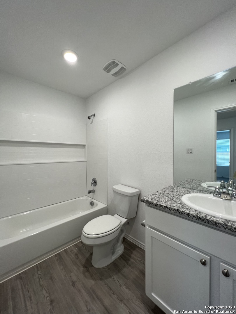 13819 Llama Place San Antonio, TX 78252 - Photo 20 of 37 a bathroom with a granite countertop toilet a sink and a mirror
