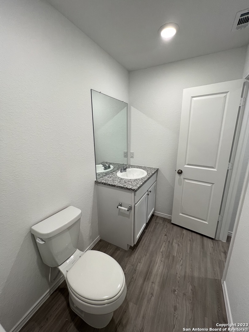 13819 Llama Place San Antonio, TX 78252 - Photo 22 of 37 a bathroom with a granite countertop toilet a sink and mirror