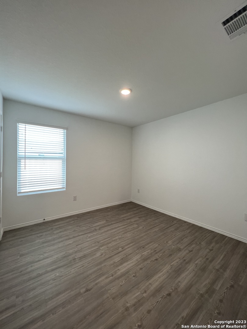 13819 Llama Place San Antonio, TX 78252 - Photo 23 of 37 an empty room with wooden floor and windows