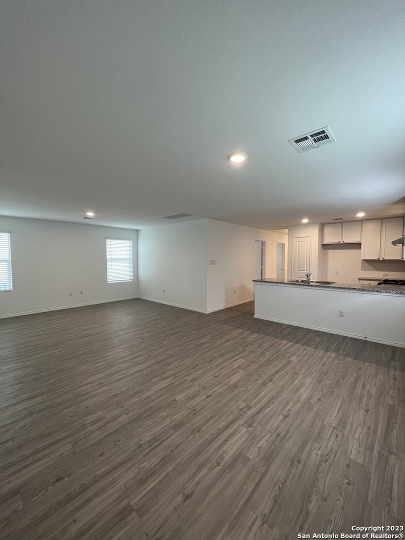 13819 Llama Place San Antonio, TX 78252 - Photo 9 of 37 an empty room with wooden floor and windows