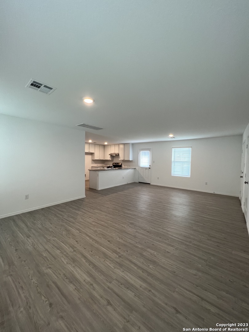 13819 Llama Place San Antonio, TX 78252 - Photo 10 of 37 an empty room with wooden floor and windows