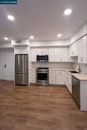 a large kitchen with a stove top oven cabinets and stainless steel appliances