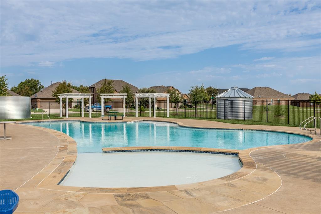 2908 Frio Road Little Elm, TX 75068 - Photo 25 of 26 Community pool featuring a freeform design, integrated shallow entry, and surrounding concrete decking with stone accents