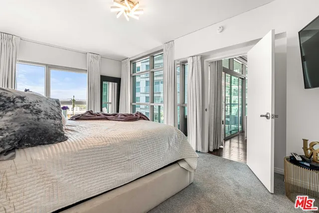 a spacious bedroom with a bed and a chandelier