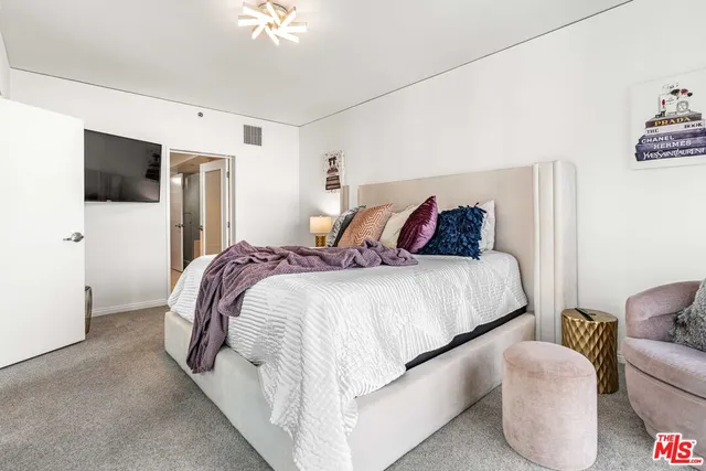 a bedroom with bed and a flat screen tv