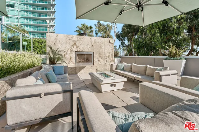 a outdoor space with patio the couches and a fireplace