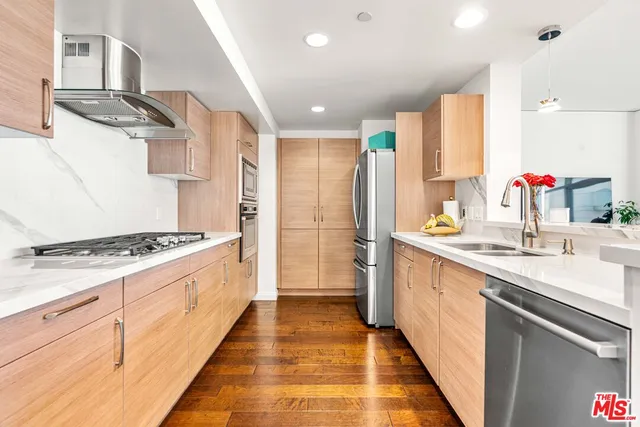 a kitchen with stainless steel appliances a sink stove and cabinets