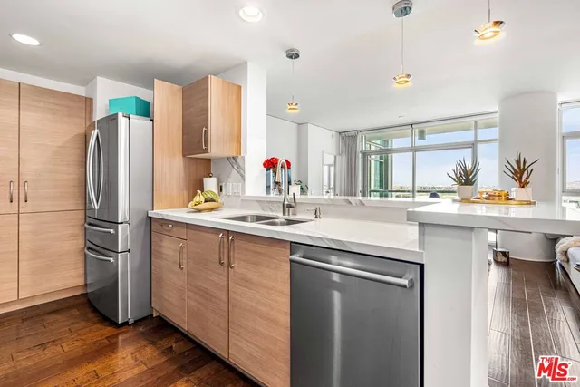 a kitchen with stainless steel appliances a sink cabinets and wooden floor