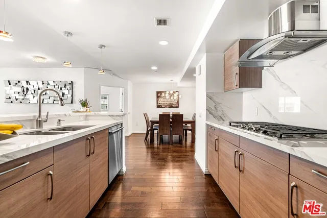 a kitchen with stainless steel appliances kitchen island granite countertop a stove a sink and a refrigerator