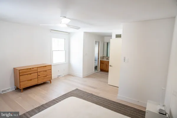 an empty room with wooden floor cabinet and window