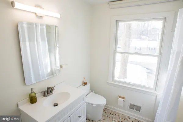a bathroom with a sink a toilet and a window