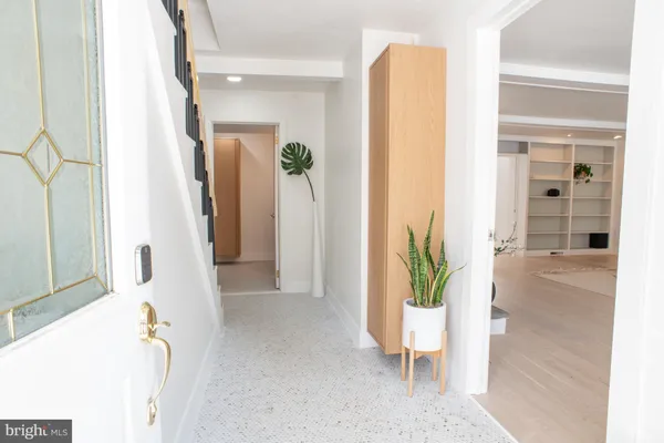 a view of a hallway with wooden floor and a potted plant