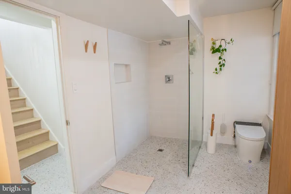 a bathroom with a granite countertop shower and a toilet