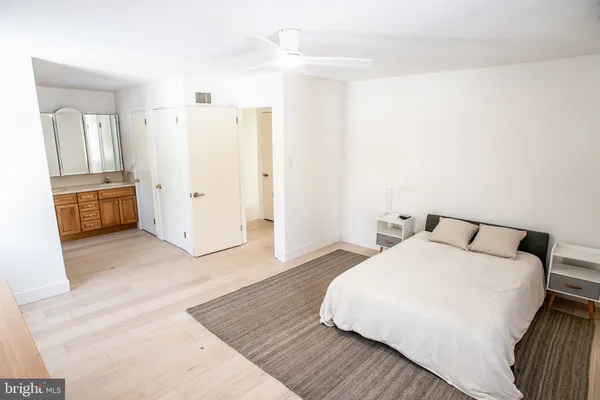 a spacious bedroom with a bed and wooden floor