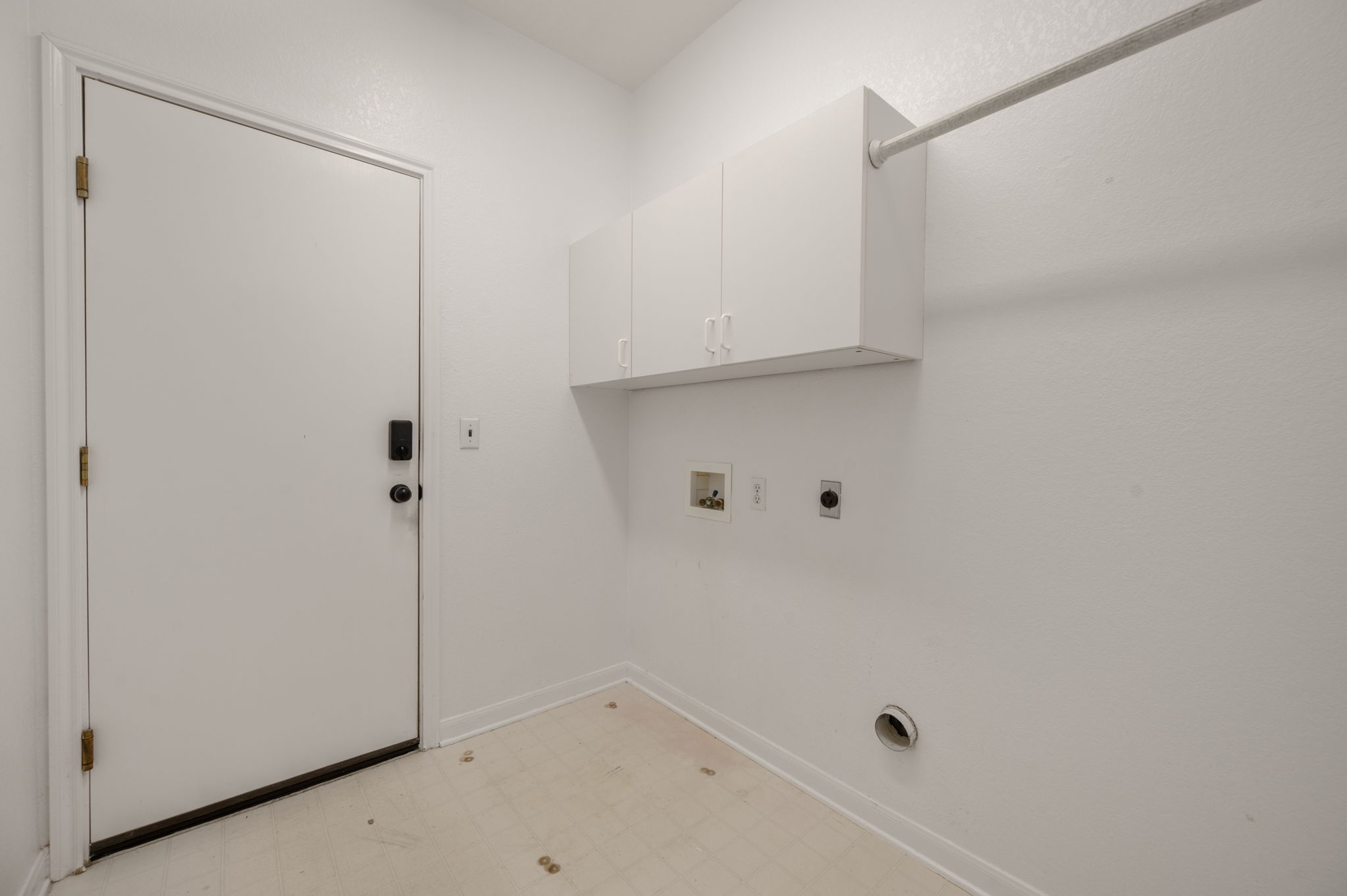118 Bass Street Georgetown, TX 78633 - Photo 32 of 40 Functional laundry room offers upper cabinetry for storage and a convenient clothes rod for hanging items.