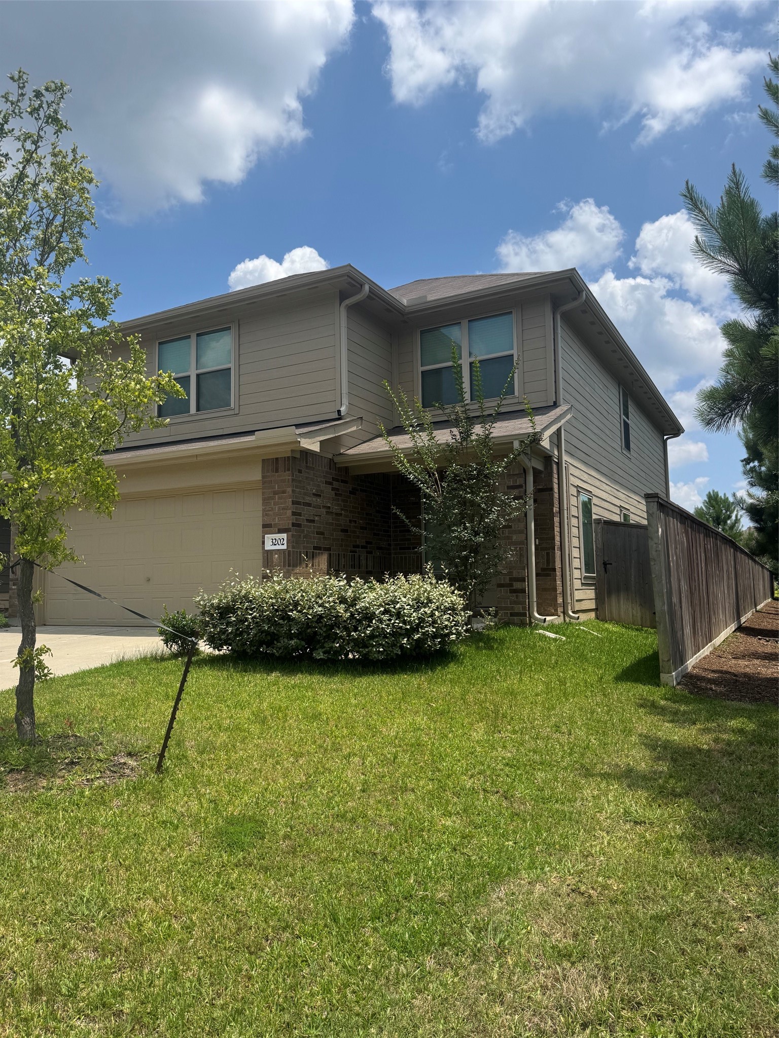 3202 Holly Stokes Way Conroe, TX 77301 - Photo 3 of 24 a front view of a house with a garden and yard