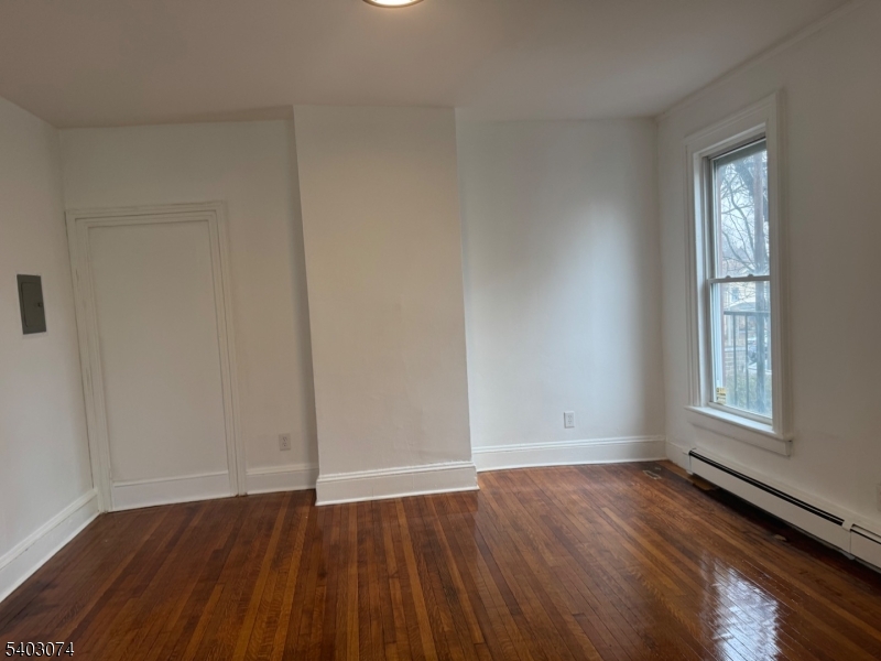 92 Cleveland Street Orange, NJ 07050 - Photo 16 of 16 an empty room with wooden floor and windows