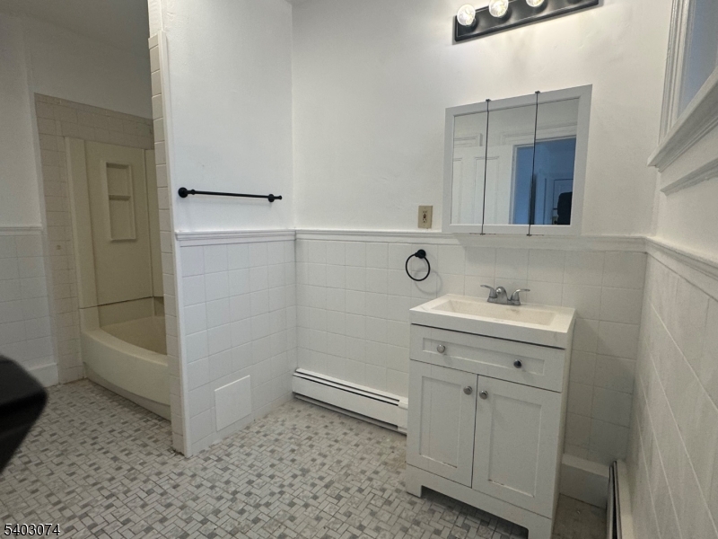92 Cleveland Street Orange, NJ 07050 - Photo 5 of 16 a bathroom with a sink a toilet and shower