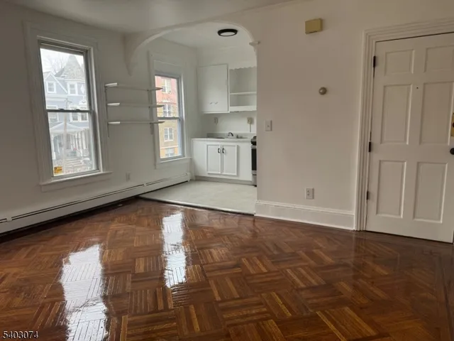 a view of empty room with wooden floor and cabinet