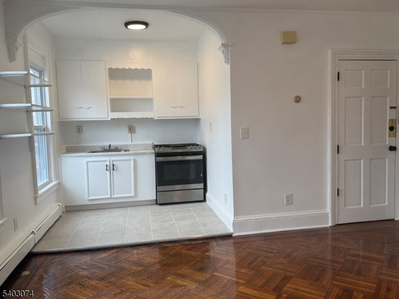 92 Cleveland Street Orange, NJ 07050 - Photo 10 of 16 a kitchen with stainless steel appliances granite countertop a stove a sink and a refrigerator