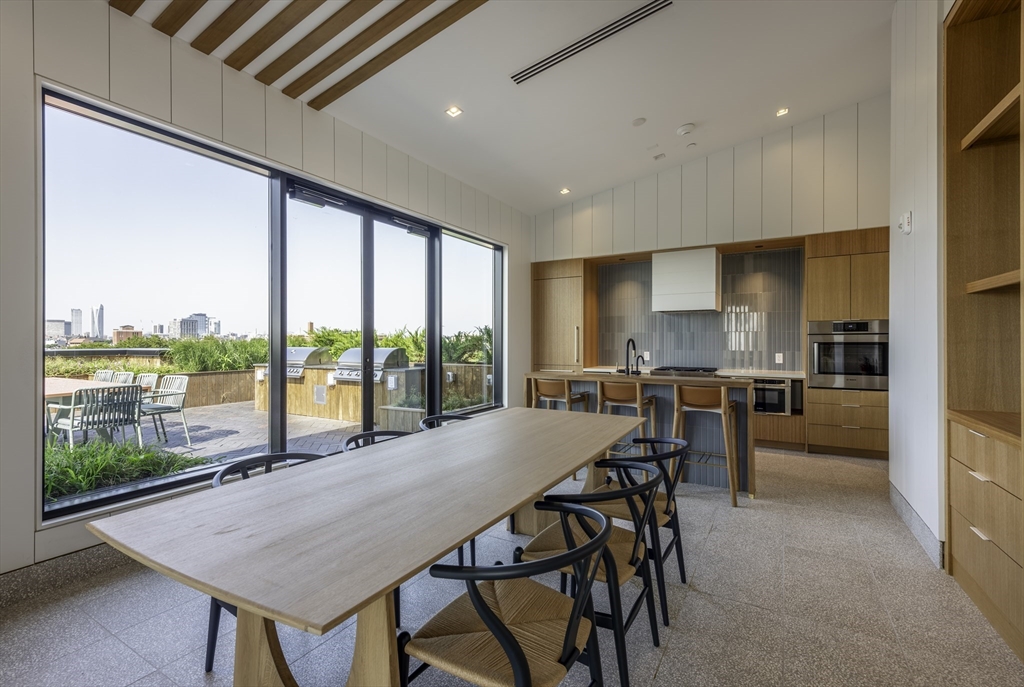 282 Bremen Street, Unit 237 Boston, MA 02128 - Photo 21 of 21 a kitchen with a table chairs and flat screen tv