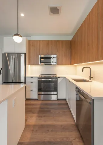 a kitchen with kitchen island a sink stainless steel appliances and cabinets