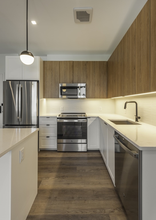 282 Bremen Street, Unit 237 Boston, MA 02128 - Photo 3 of 21 a kitchen with kitchen island a sink stainless steel appliances and cabinets