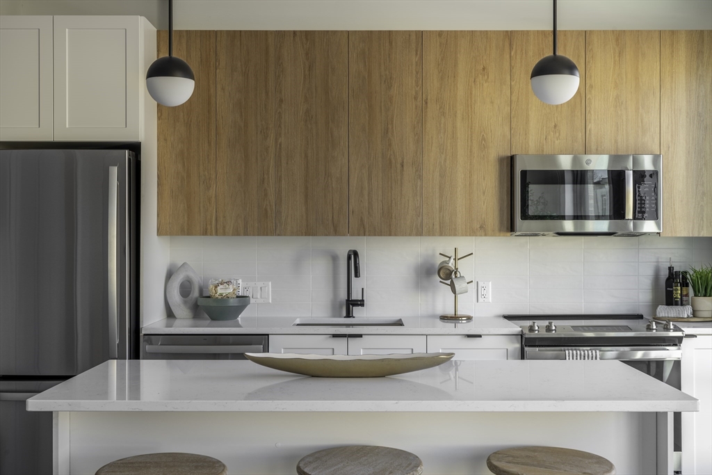 282 Bremen Street, Unit 237 Boston, MA 02128 - Photo 5 of 21 a kitchen with a sink a microwave and cabinets