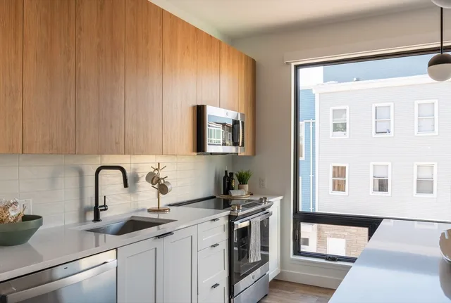 a kitchen with granite countertop a sink stainless steel appliances and cabinets