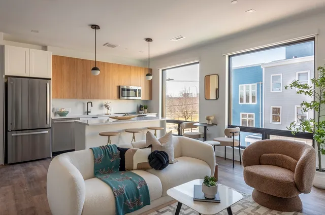 a living room with furniture kitchen and a large window