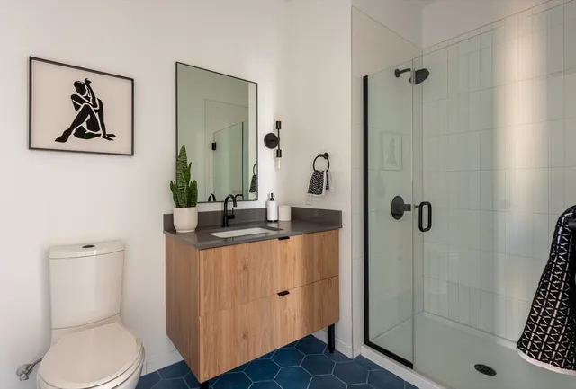 a bathroom with a granite countertop sink a toilet and shower