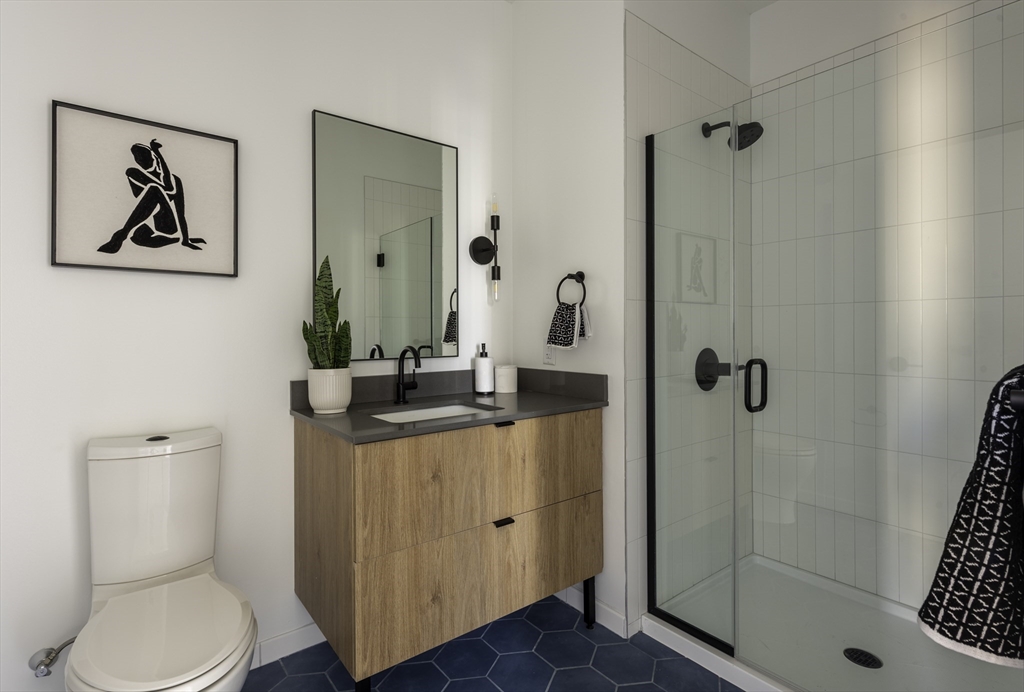 282 Bremen Street, Unit 237 Boston, MA 02128 - Photo 8 of 21 a bathroom with a granite countertop sink a toilet and shower