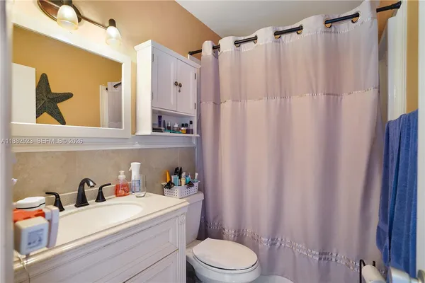 a bathroom with a sink a toilet and shower curtain