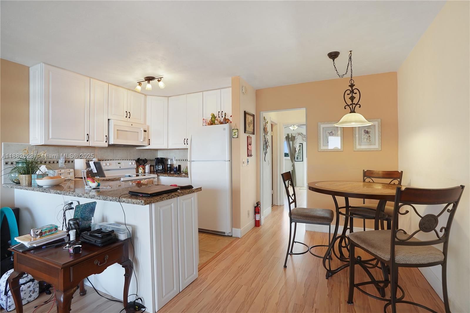 1000 Southwest 11th Avenue, Unit 17E Hallandale Beach, FL 33009 - Photo 4 of 18 a kitchen with stainless steel appliances granite countertop a stove a refrigerator a sink dishwasher with a dining table and chairs